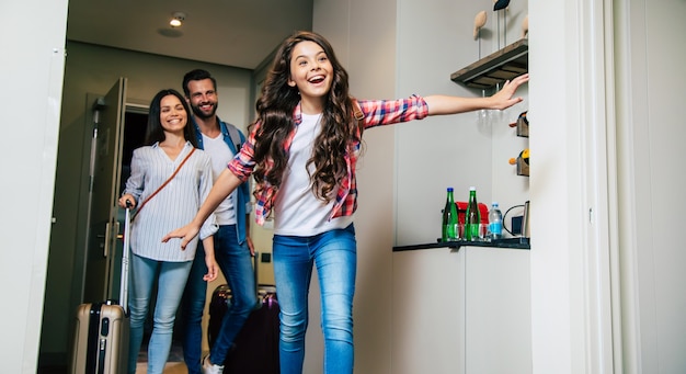 Una famiglia felice che entra nella stanza d'albergo