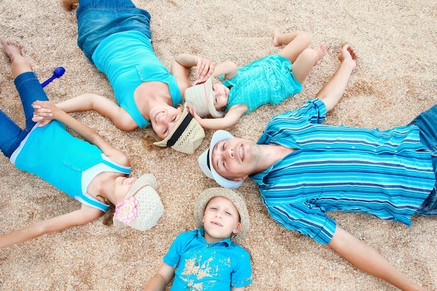 Una famiglia felice che gioca in riva al mare sullo sfondo della sabbia