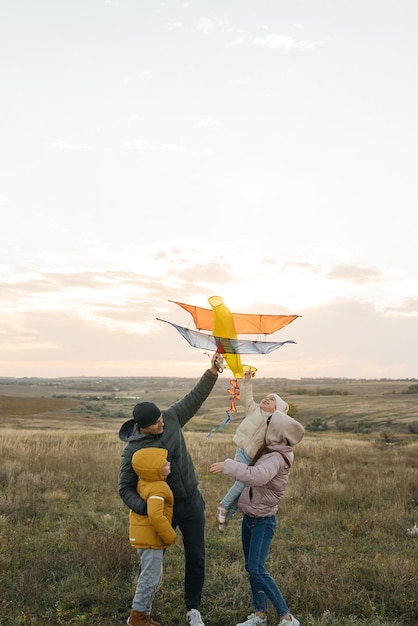 Una famiglia felice con bambini fa volare un aquilone e trascorre del tempo insieme all'aperto in una riserva naturale Infanzia felice e vacanze in famiglia Libertà e spazio