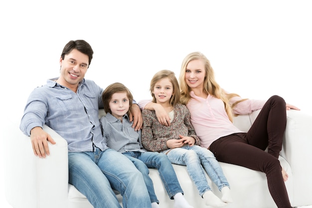 Una famiglia felice con bambini sul divano isolato