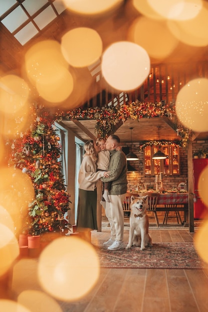 Una famiglia felice e autentica durante l'inverno, insieme a godersi le vacanze con il cane a Natale.