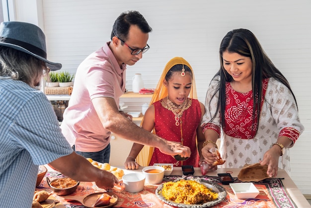 Una famiglia indiana in piedi in cucina Si aiutano a vicenda a preparare il cibo