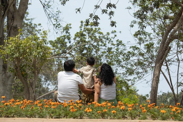 una famiglia si siede in un campo di fiori con un uomo e un bambino