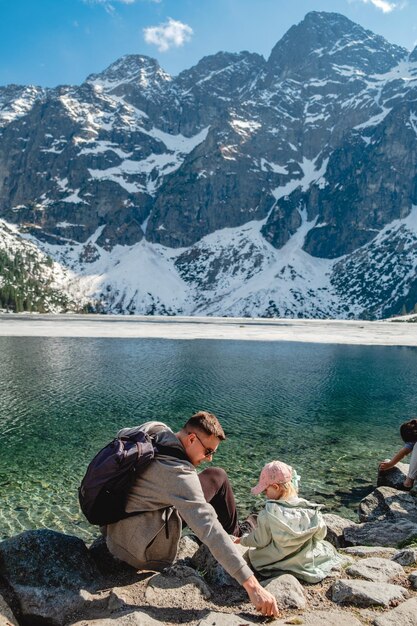 Una famiglia si trova sulla riva di un lago Morskie Oko montagne dei Tatra