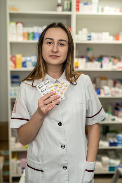 Una farmacista donna controlla gli scaffali per la presenza di farmaci