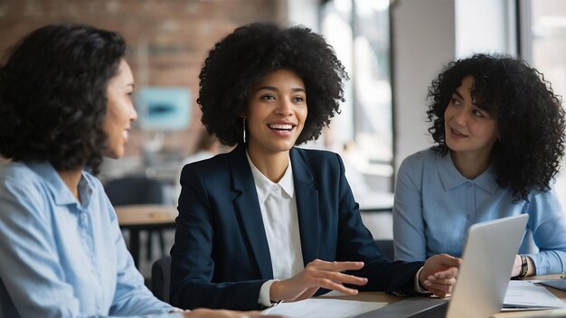 Una felice donna d'affari afroamericana che parla con le sue colleghe mentre lavora in ufficio.