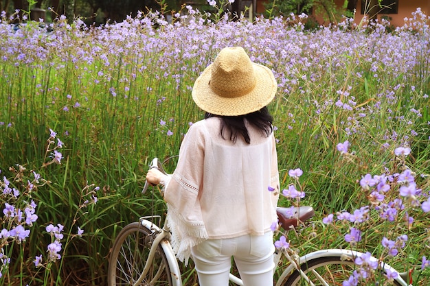 Una femmina con la sua bicicletta che ammira il bellissimo campo di fiori viola pastello