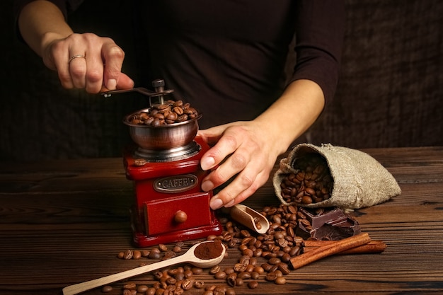 Una femmina di mani e macinino da caffè