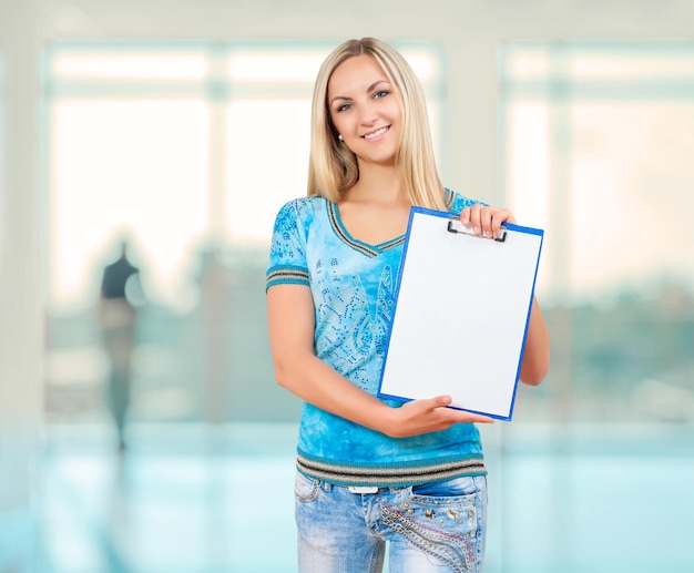 Una femmina sorridente che tiene il clopboard vuoto