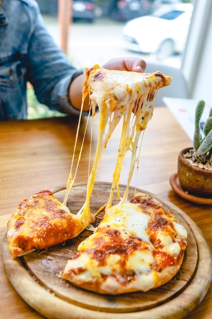 Una fetta di mozzarella pizza vegetariana fresca calda Pizza italiana Margherita in mano