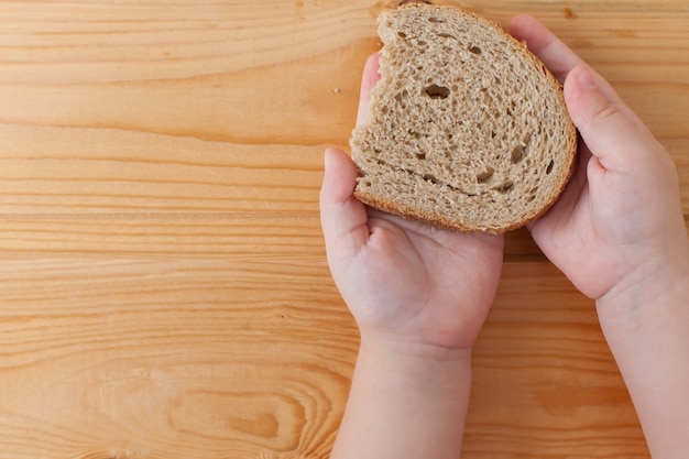 Una fetta di pane secco nelle mani dei bambini. Cibo.