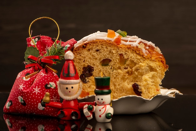 Una fetta di panettone accanto agli addobbi natalizi.