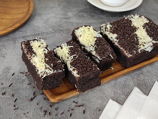 Una fetta di torta al cioccolato con sopra scaglie di cioccolato bianco.