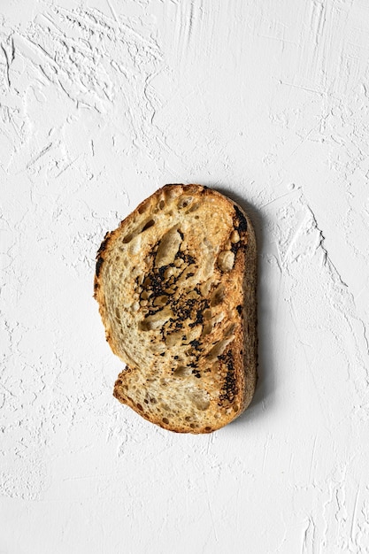 Una fetta tostata di pane integrale su sfondo bianco vista dall'alto