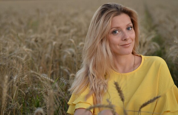 una figlia e una madre in un campo di grano sorridono e parlano con noncuranza