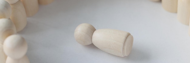 Una figura di legno che giace in cerchio di molte persone rappresenta crimini di discriminazione e violenza