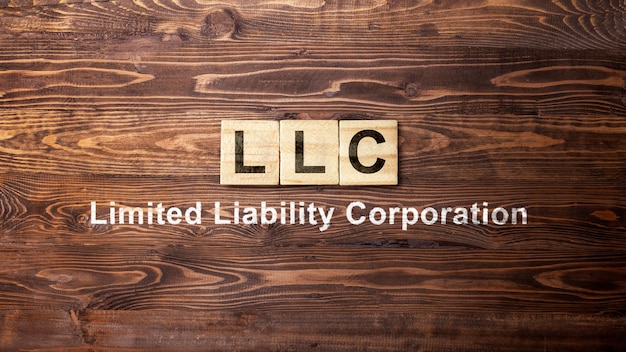 Una fila di cubi di legno con il testo LLC l'acronimo di Limited Liability Company