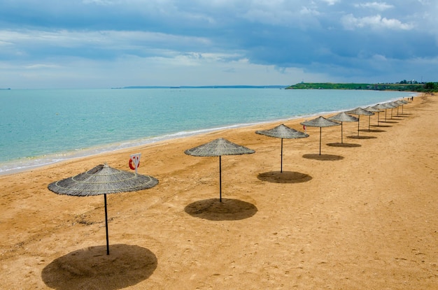 Una fila di ombrelloni rotondi sulla spiaggia vicino al mare.