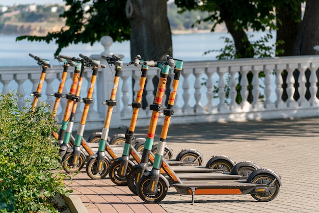 Una fila di scooter parcheggiati sul marciapiede della città, veicolo elettrico