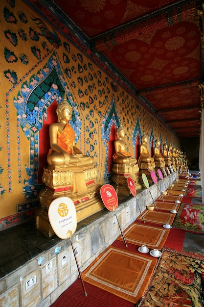 Una fila di statue di buddha in un tempio con un cartello che dice "buddha" su di essa