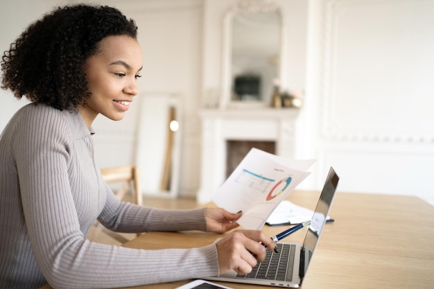 Una finanziera lavora con i documenti sul posto di lavoro di una società finanziaria in ufficio utilizza un tablet e Internet