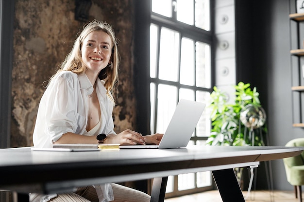 Una finanziera lavora nel posto di lavoro di un hotel utilizza un laptop che comunica con un cliente