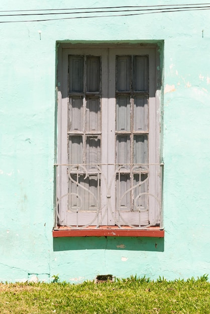 Una finestra con una parete verde e una cornice bianca con su scritto "la parola". "