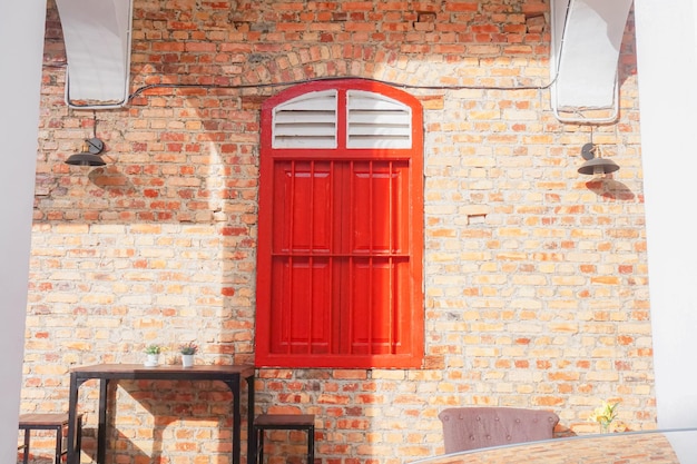 Una finestra rossa con la scritta sul lato di un muro di mattoni