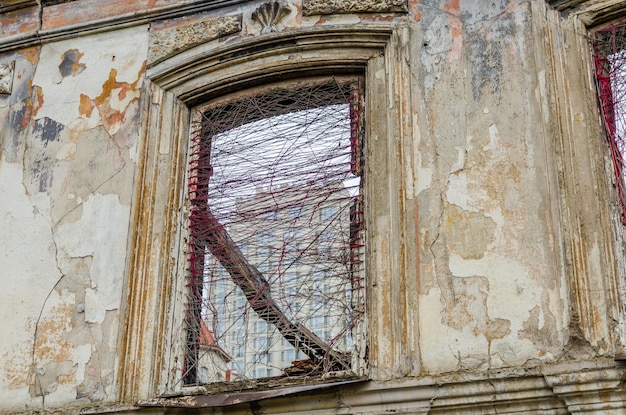 Una finestra rotta nel muro di una vecchia casa.