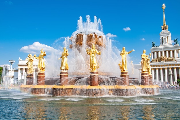 Una fontana con statue d'oro degli dei davanti.