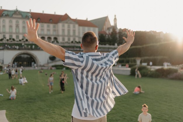 Una foto della schiena dell'uomo con le mani tese nel giardino reale