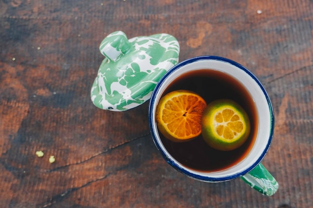 Una foto di tè al limone servita tradizionalmente in tazza blirik isolato sullo sfondo di legno