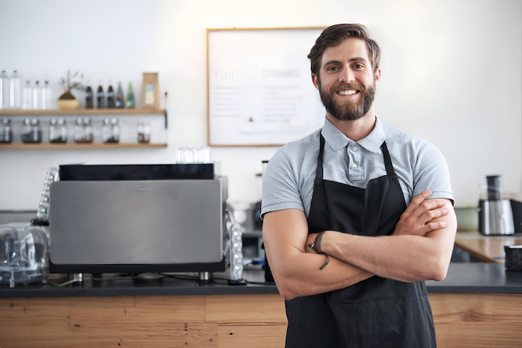 Foto una foto di un bel giovane barista in piedi in un caffè