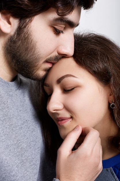 Una foto sensuale di una coppia di innamorati in piedi vicini. Una giovane donna appoggiata al suo fidanzato