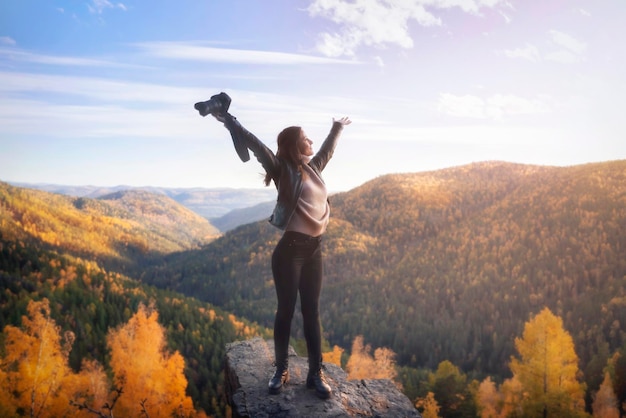 Una fotografa in cima alla montagna allargò le braccia nella gioia della libertà e dello spazio Riprese paesaggistiche della natura e del concetto di viaggio in autunno