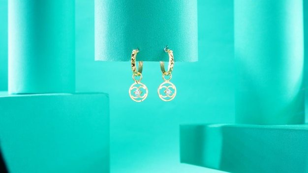 una fotografia di un paio di orecchini d'oro su sfondo blu