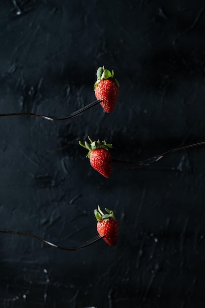 Una fragola infilzata con una forchetta