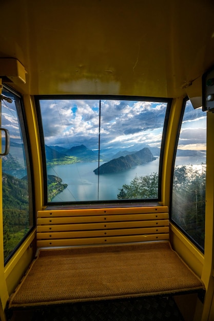 Una funivia fotografata dall'interno dalla vista della finestra si vede un lago con le montagne