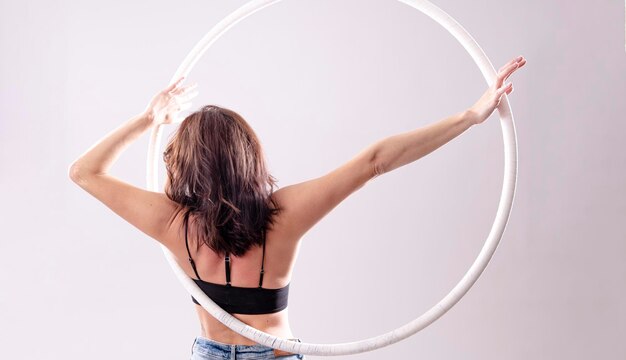 Una ginnasta femminile del cerchio aereo che esegue gli esercizi su un cerchio aereo