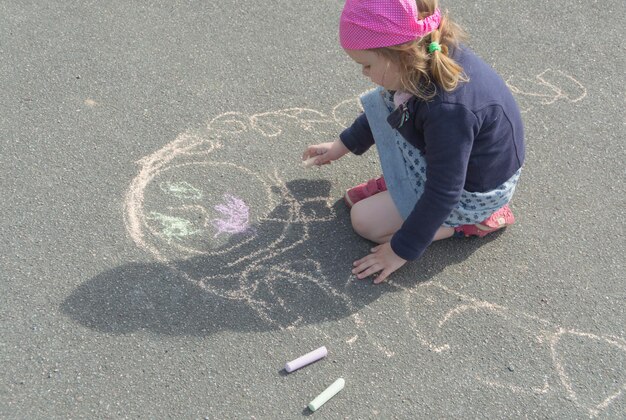 Una giornata di sole sul marciapiede in gesso e disegna una madre una bambina.