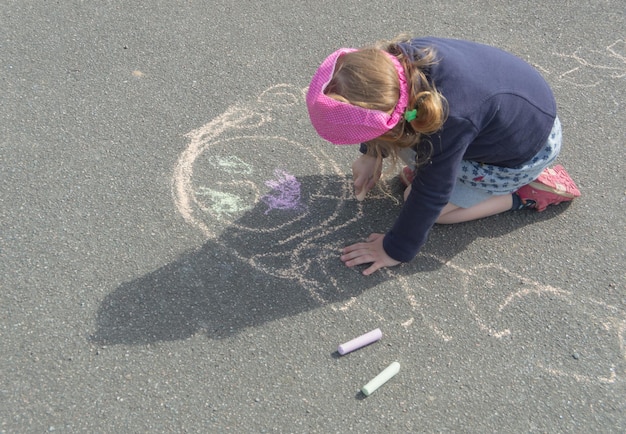 Una giornata di sole sul marciapiede in gesso e disegna una madre una bambina.