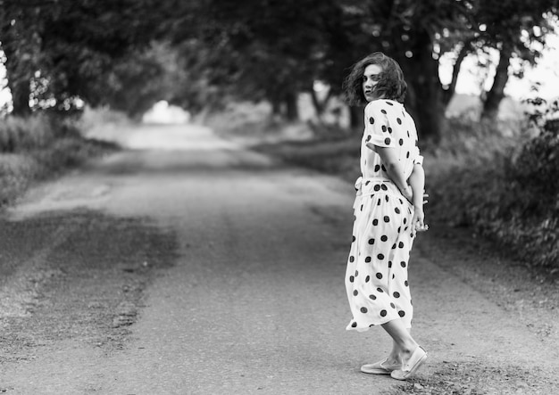 Una giovane bella donna alla moda che attraversa la strada