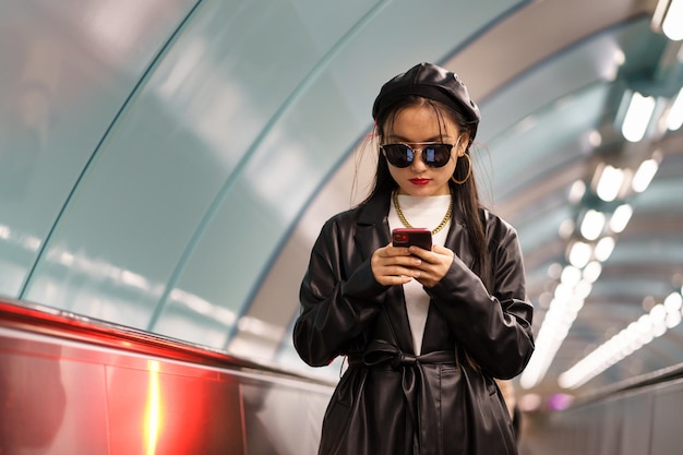 Una giovane blogger coreana che pubblica sui social media guida la scala mobile dalla stazione della metropolitana