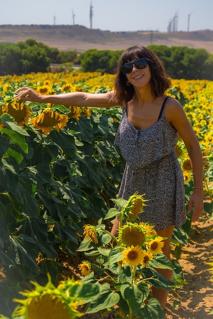 Una giovane brunetta caucasica che gode di alcuni bei girasoli