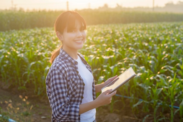 Una giovane contadina intelligente con tablet sul campo, innovazioni ad alta tecnologia e agricoltura intelligente