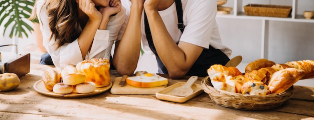 Una giovane coppia adulta felice che fa colazione e beve caffè insieme in una cucina accogliente a casa la mattina a casa Preparando un pasto e sorridendo