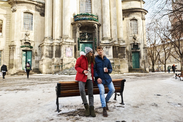 Una giovane coppia alla moda cammina in città a christmastime