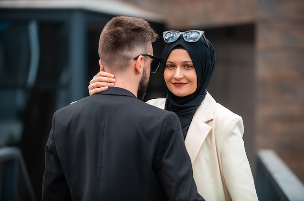 Una giovane coppia alla moda musulmana felice che posa fuori