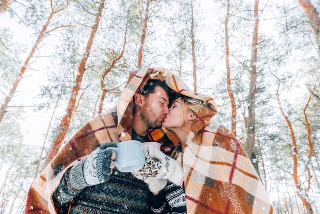 Una giovane coppia amorevole sta riposando in montagna in una foresta innevata. concetto di riposo articolare