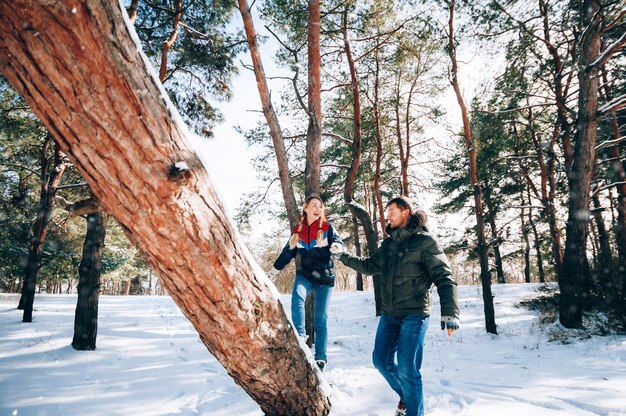 Una giovane coppia amorosa sta riposando nelle montagne in una foresta innevata. concetto di riposo articolare